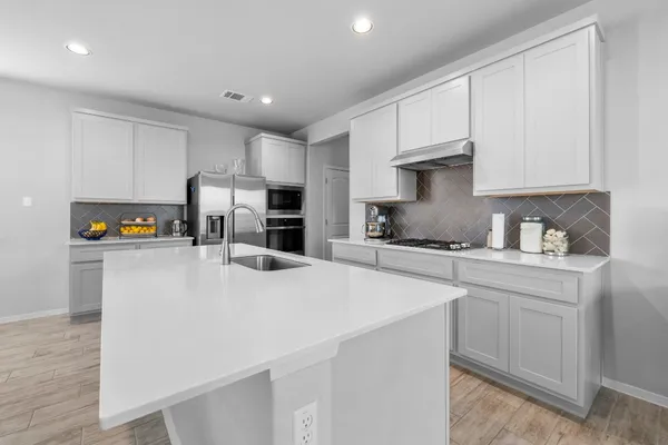 a kitchen with stainless steel appliances a refrigerator sink and cabinets