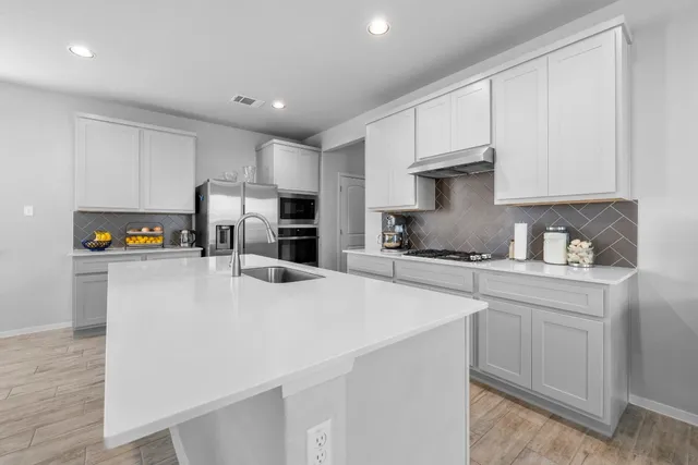 a kitchen with stainless steel appliances a refrigerator sink and cabinets