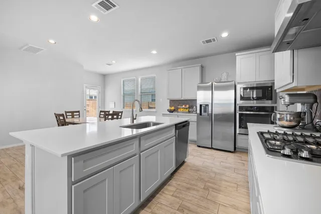 a kitchen with stainless steel appliances a refrigerator sink and stove