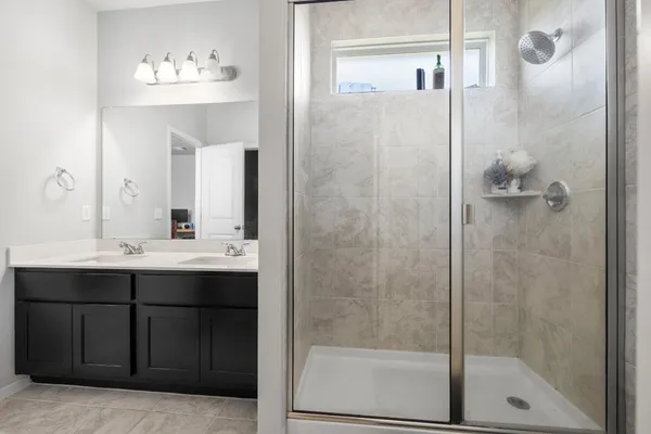 a bathroom with a shower sink and mirror