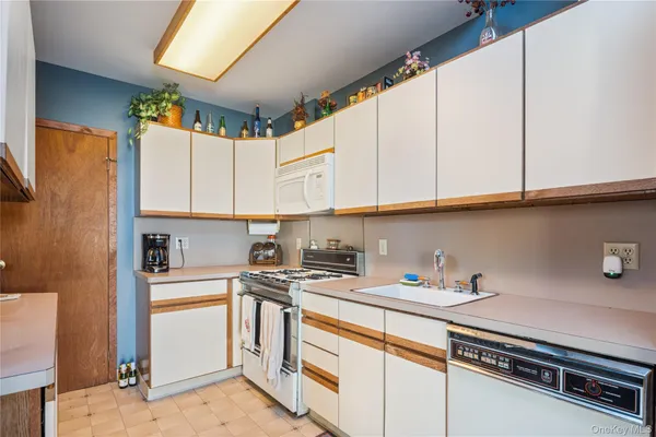 a kitchen with stainless steel appliances white cabinets and a stove top oven