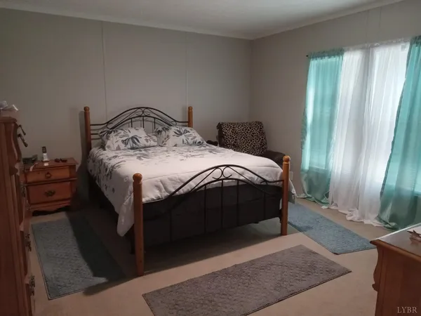 a spacious bedroom with a bed a window and gate