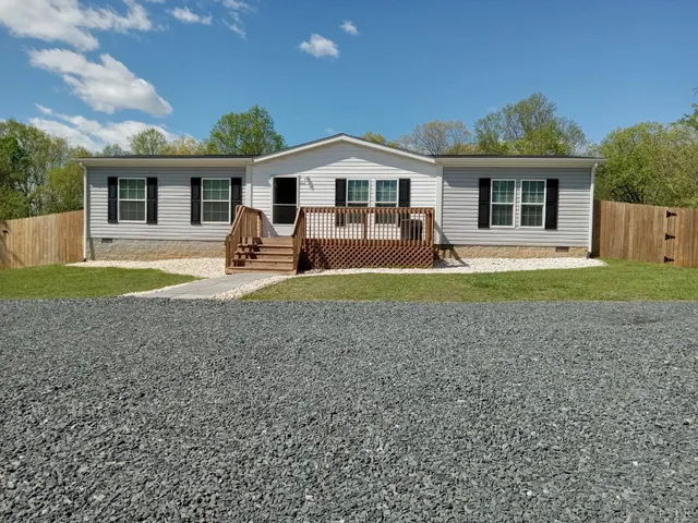 a view of a house with a yard and large tree