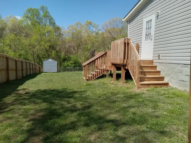 a view of a house with backyard and a trees
