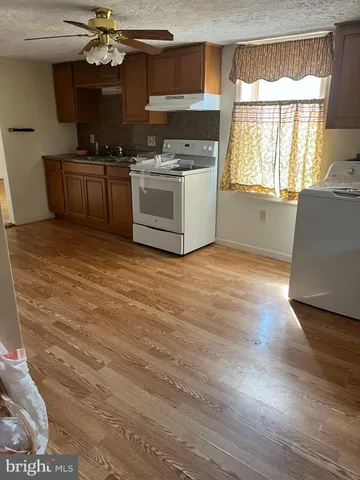 a kitchen with granite countertop a stove and a wooden floors
