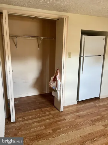 a view of empty room with wooden floor and cabinet