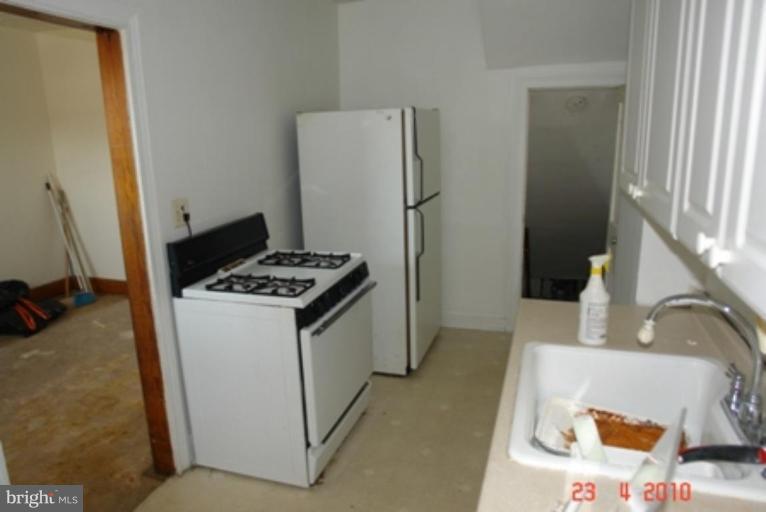 95 Willow Spring Road Dundalk, MD 21222 - Photo 2 of 5 a kitchen with a refrigerator and a stove top oven