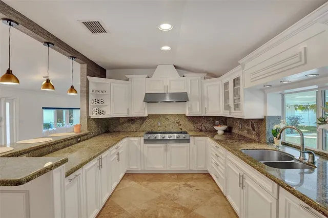 a kitchen with granite countertop a sink stainless steel appliances and cabinets