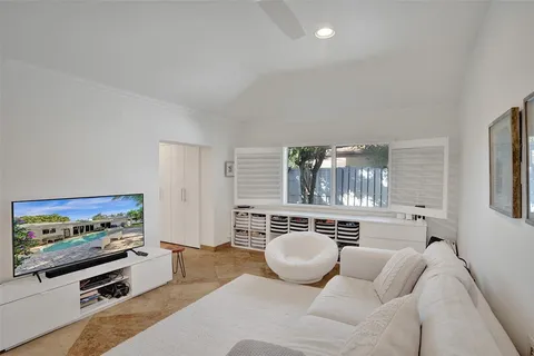 a living room with furniture a flat screen tv and gym equipment