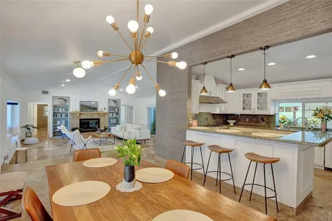 a kitchen with a table chairs stove and kitchen view
