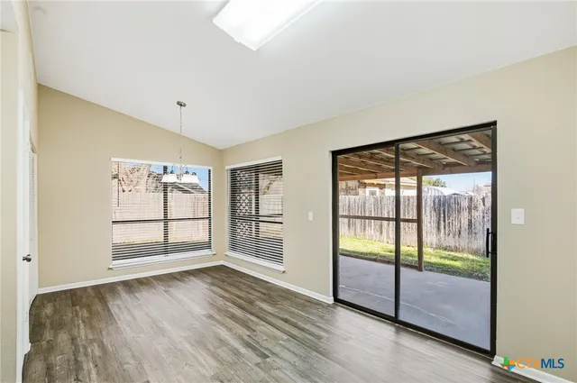 an empty room with wooden floor and door