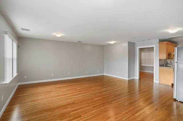 a view of an empty room with wooden floor