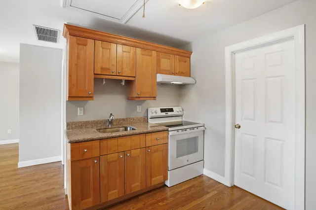 a kitchen with stainless steel appliances granite countertop a sink stove and cabinets