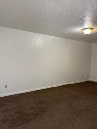 an empty room with wooden floor and windows in it