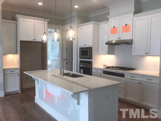 1005 Norris Street Raleigh, NC 27604 - Photo 16 of 25 a kitchen with stainless steel appliances granite countertop a sink and a refrigerator