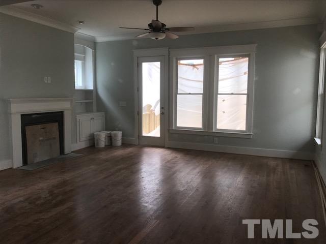 1005 Norris Street Raleigh, NC 27604 - Photo 8 of 25 an empty room with wooden floor fireplace and windows