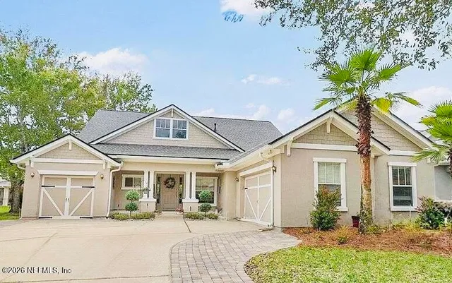 a front view of a house with a yard and potted plants