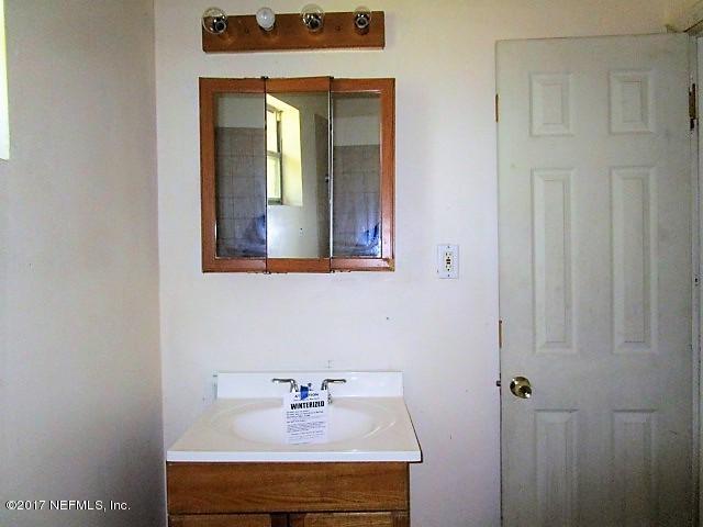 6912 Corday Road Jacksonville, FL 32208 - Photo 6 of 10 a bathroom with a sink and a mirror