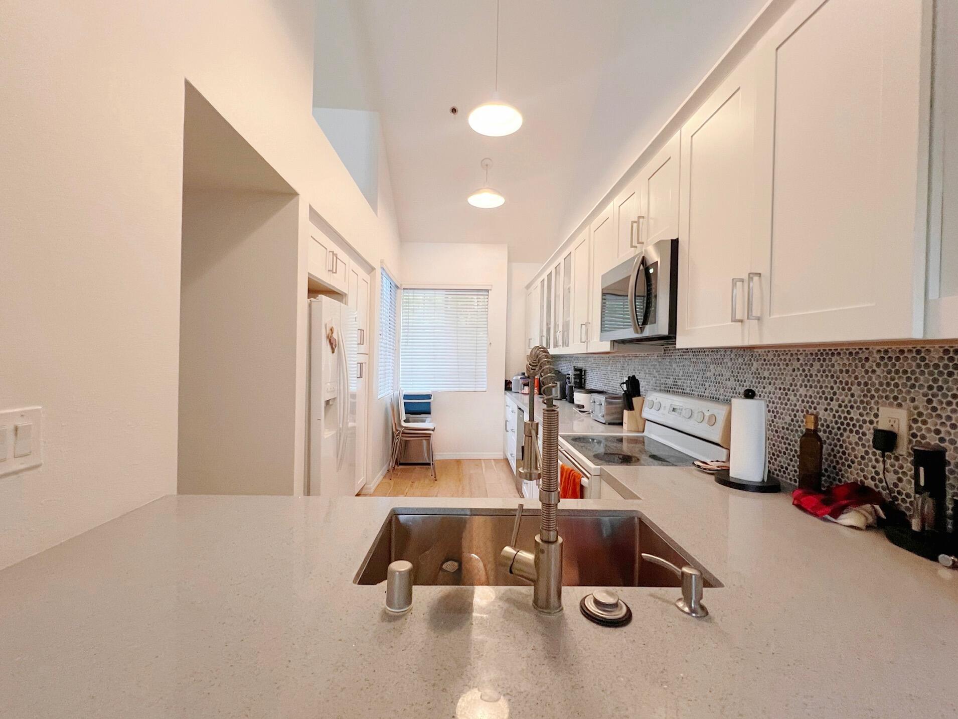 20371 Bluffside Circle, Unit B404 Huntington Beach, CA 92646 - Photo 15 of 40 a room with kitchen island a sink a stove and a refrigerator