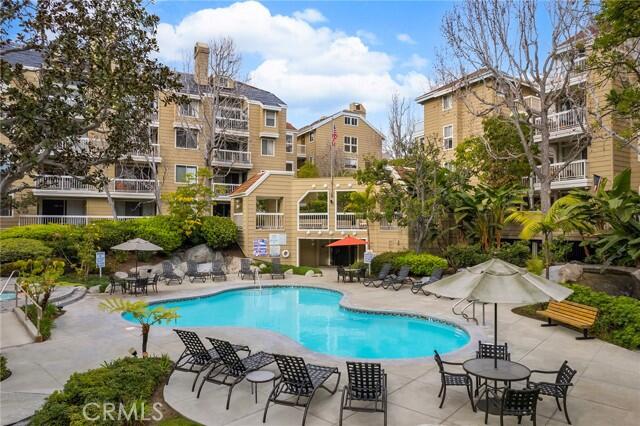 20371 Bluffside Circle, Unit B404 Huntington Beach, CA 92646 - Photo 35 of 40 a swimming pool with outdoor seating and yard