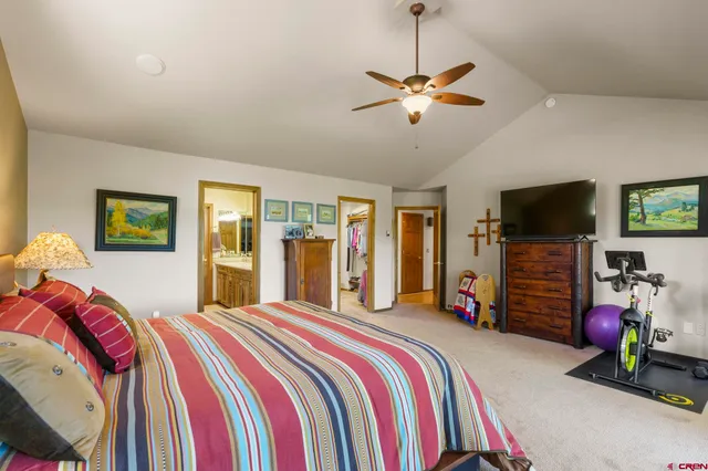 a bedroom with a bed and a flat tv screen on dresser