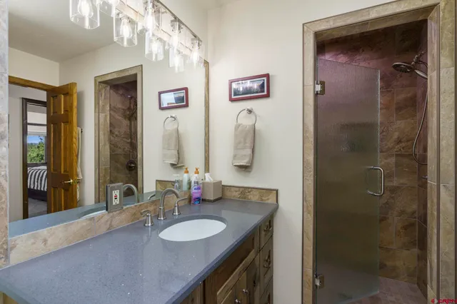 a bathroom with a granite countertop sink shower and a mirror