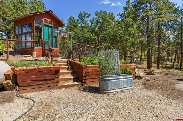 a backyard of a house with wooden fence and a bench