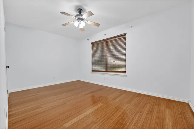 a view of a backyard with large trees and wooden fence