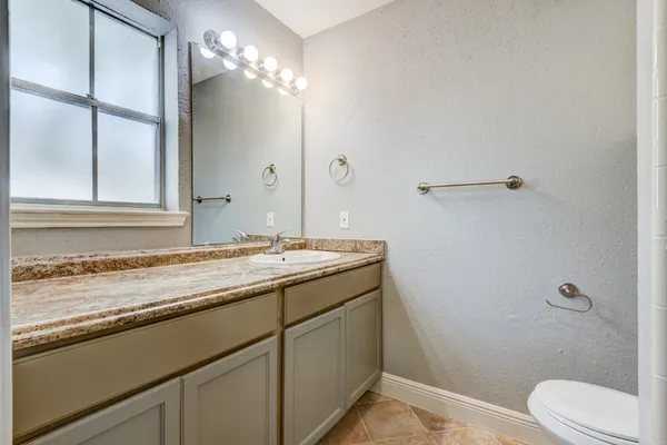 a bathroom with a sink and mirror with toilet