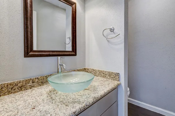 a bathroom with a granite countertop sink and a mirror