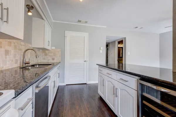 a kitchen with granite countertop white cabinets and white appliances