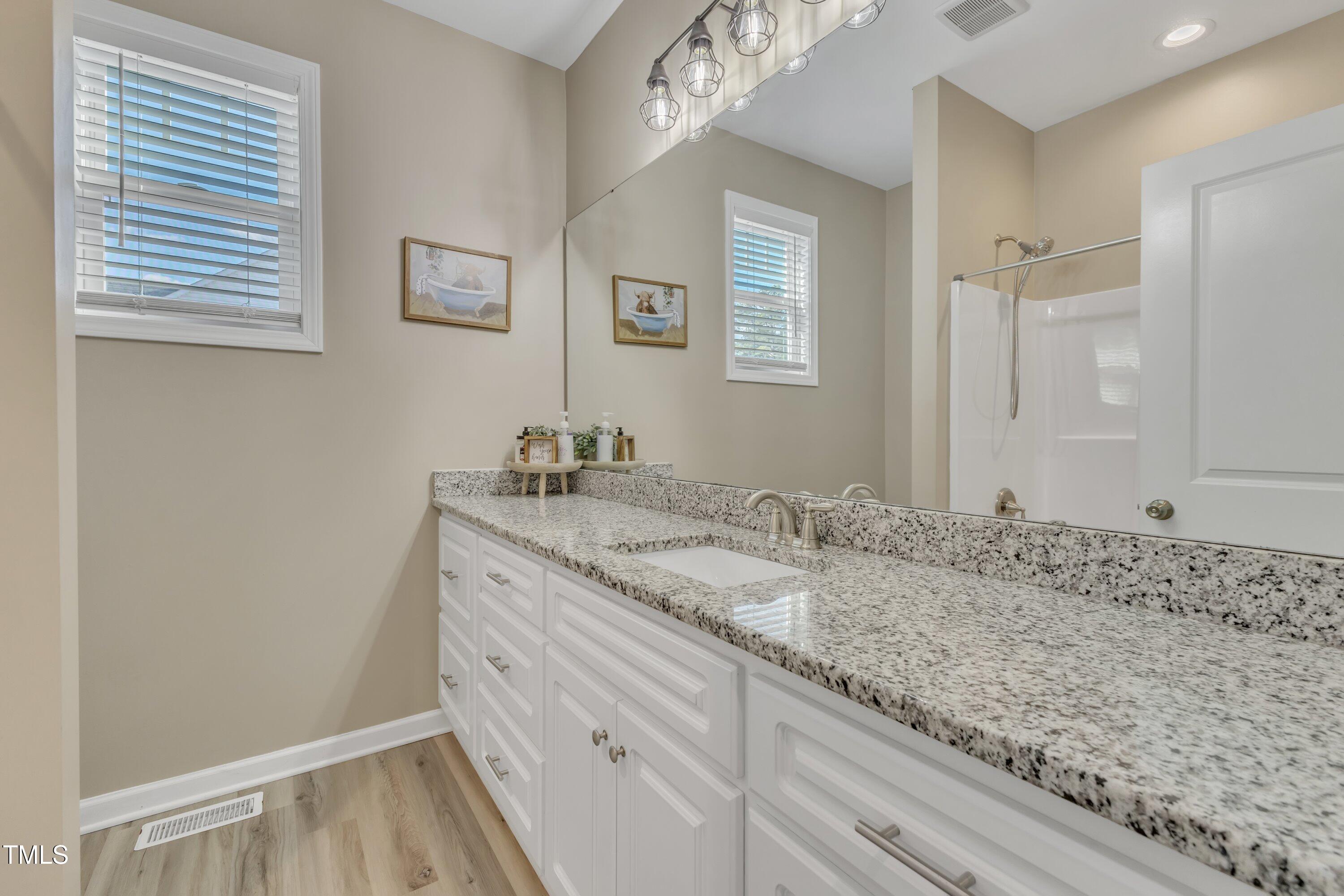 10387 Claude Lewis Road Middlesex, NC 27557 - Photo 28 of 37 a bathroom with a granite countertop sink and a mirror