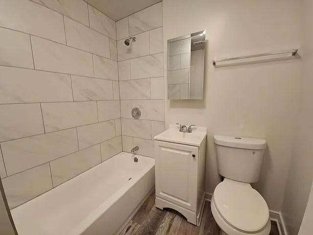 a white toilet sitting next to a bath tub