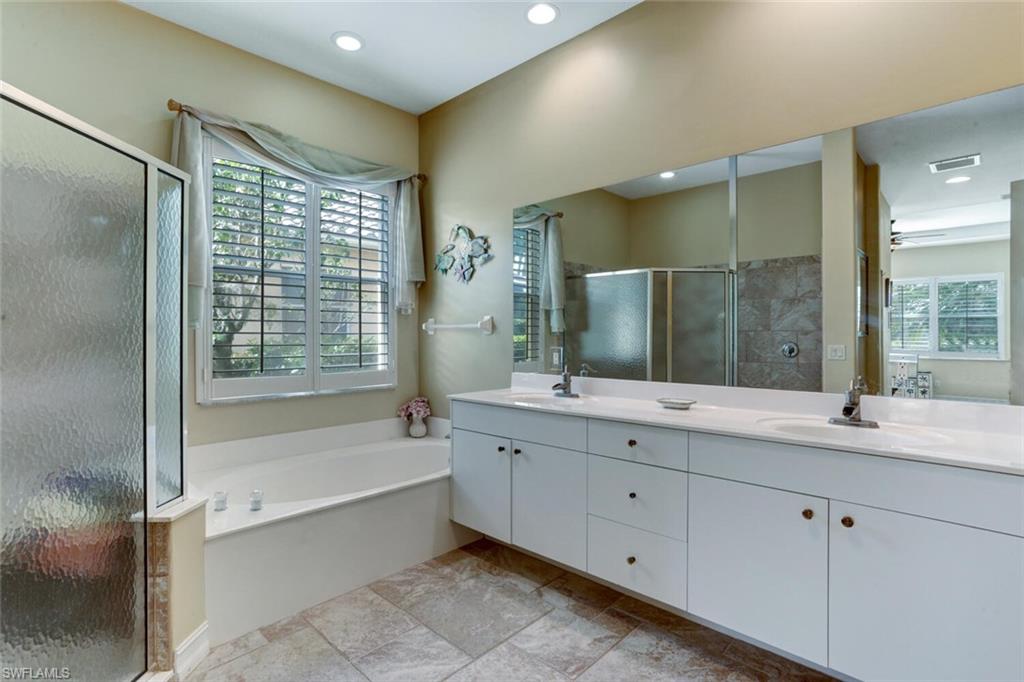 20871 Torrey Pines Way Estero, FL 33928 - Photo 24 of 43 a spacious bathroom with a double vanity sink a mirror and a bathtub