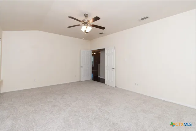 an empty room with chandelier fan