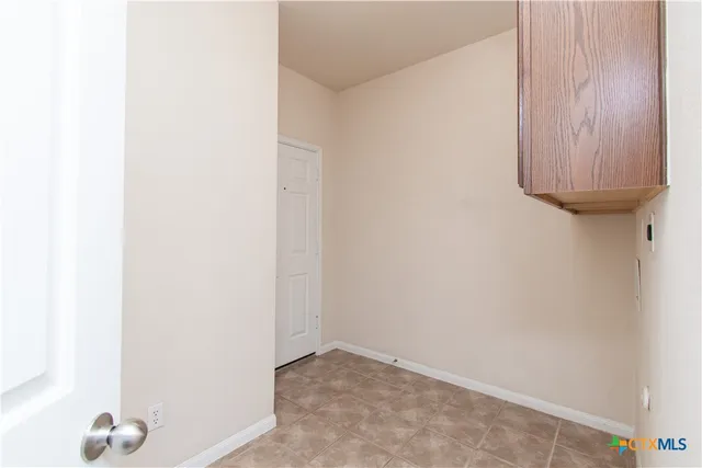 an empty room with a window and ceiling fan