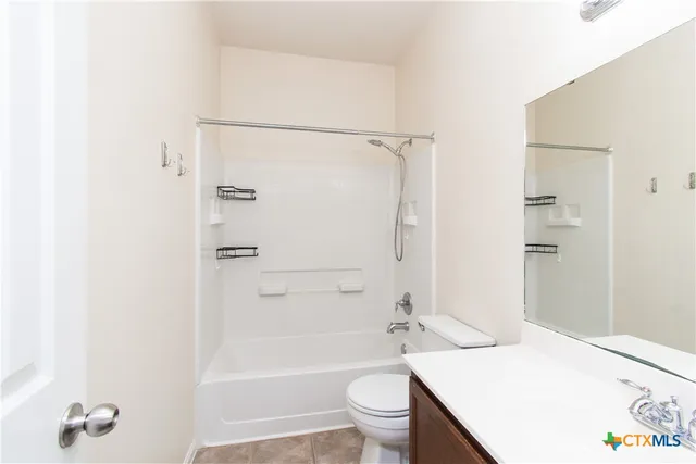 an empty room with chandelier fan and windows