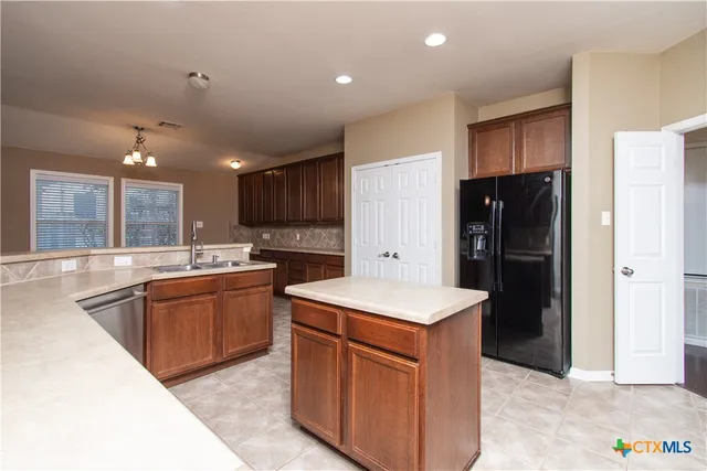 a kitchen with stainless steel appliances granite countertop a refrigerator and a sink
