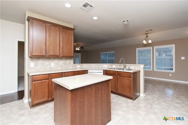 a kitchen with a sink cabinets and wooden floor