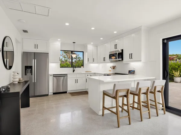 a kitchen with white cabinets stainless steel appliances and sink
