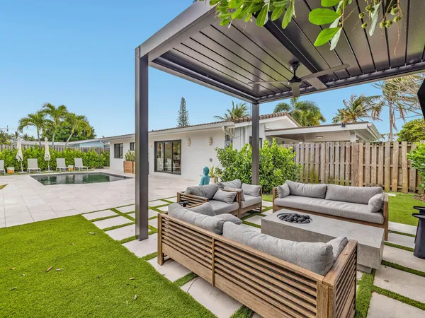 a view of a patio with couches chairs and a yard