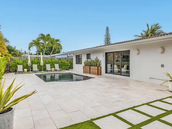 a view of a house with pool and chairs