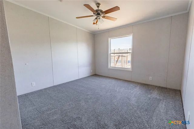 an empty room with windows and ceiling fan