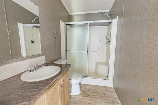 a bathroom with a granite countertop sink a toilet and shower