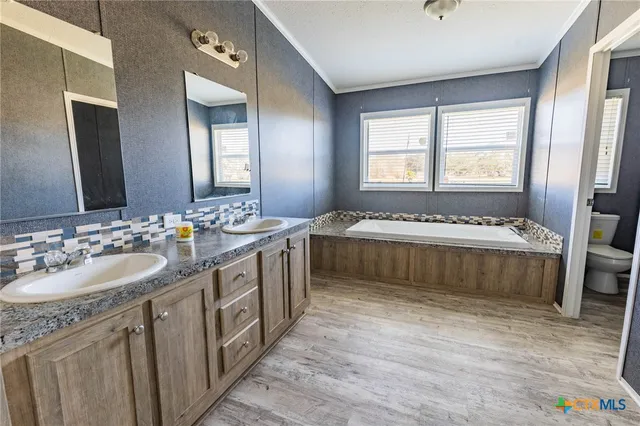a spacious bathroom with a double vanity sink and a bathtub