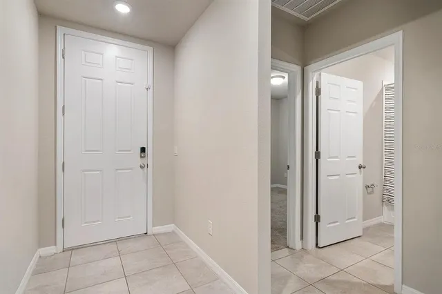 an empty room with mirror and a bathroom