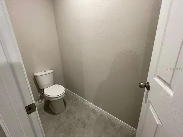 a white toilet sitting next to a shower