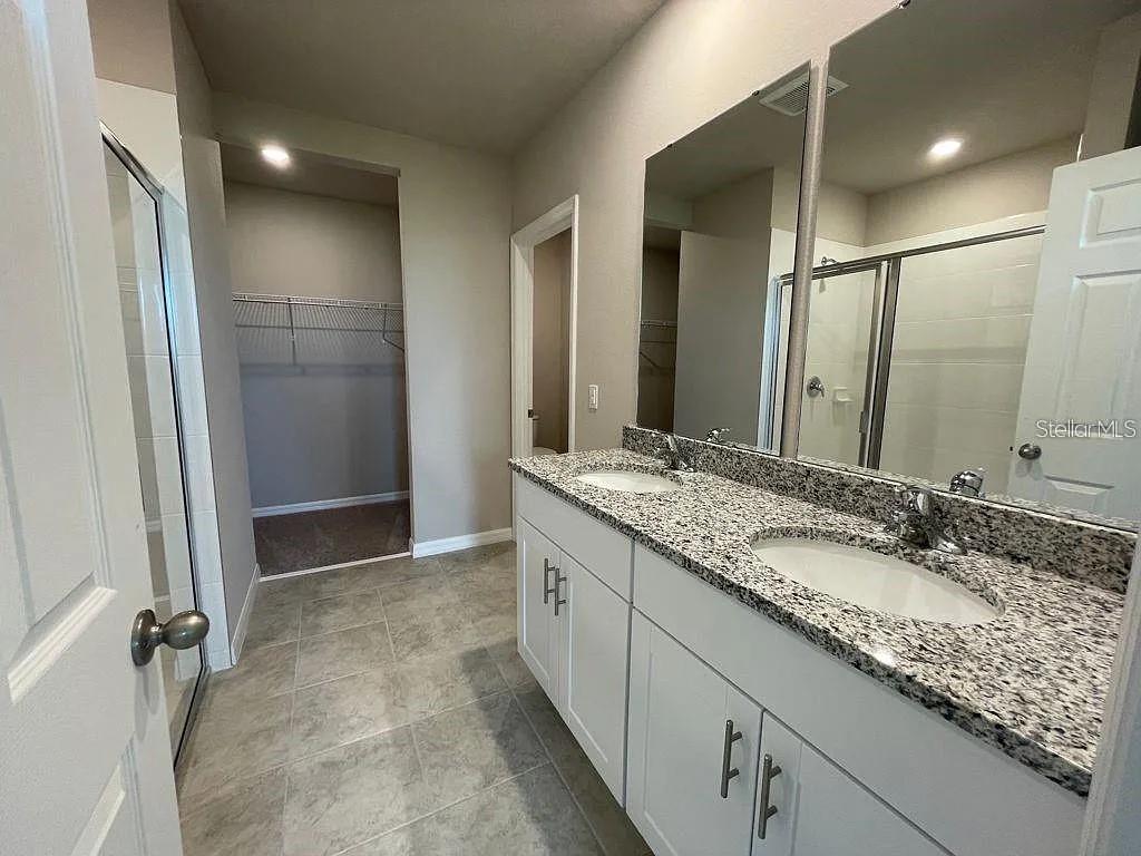 1274 Citrus Landings Boulevard Davenport, FL 33837 - Photo 17 of 20 a bathroom with a granite countertop sink and a mirror