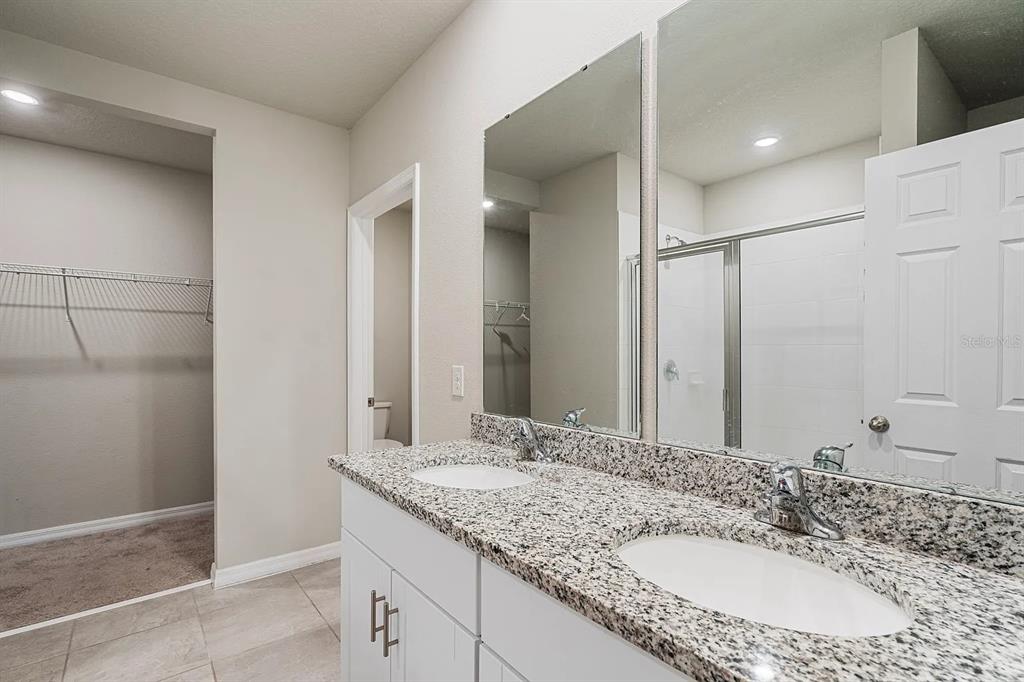 1274 Citrus Landings Boulevard Davenport, FL 33837 - Photo 19 of 20 a bathroom with a granite countertop sink and a mirror