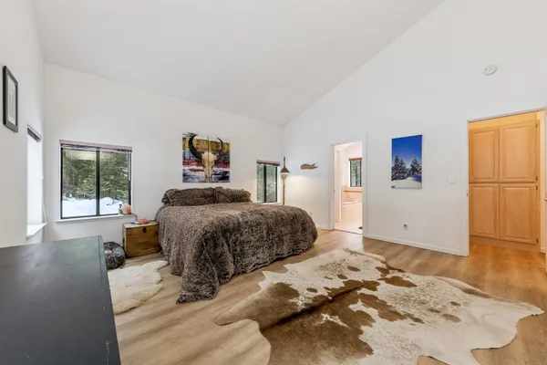 a bedroom with a bed and wooden floor